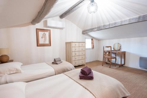 a bedroom with two beds and a table with a chair at Montjoia in L'Isle-sur-la-Sorgue