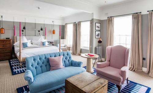 a bedroom with a bed and a couch and a chair at The Swan Hotel in Southwold