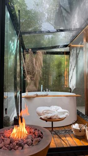 a bath tub with a fire pit in a room at Cabanas Araucária in Campos do Jordão