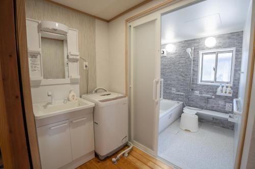 a bathroom with a sink and a toilet and a tub at 皓雲庵 in Miyakonojō
