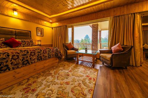 a bedroom with a bed and a chair and a window at The Orchard Retreat & Spa in Srinagar