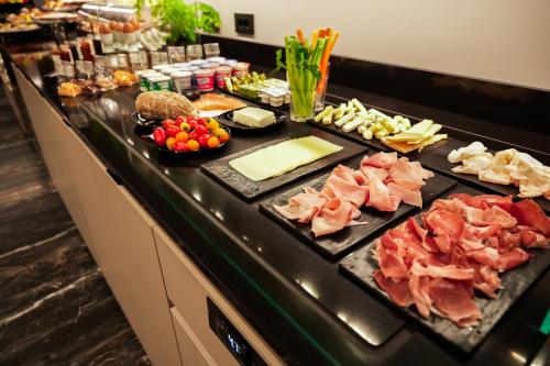 a buffet with meats and other food on a counter at Maritan Hotel & Spa in Padova