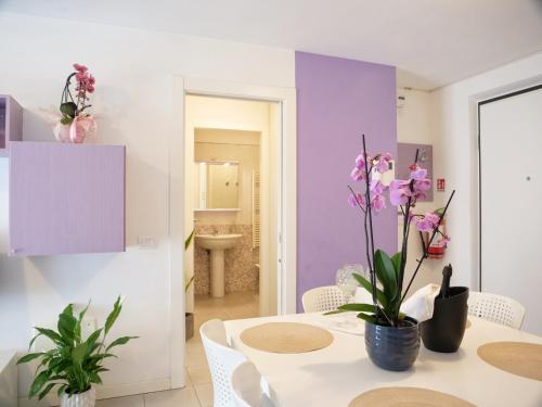 a dining room with a white table and purple walls at Mareblu Apartments Grado in Grado