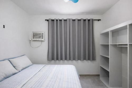 a bedroom with a bed and a window with a heater at Residencial Dois58 in Niterói