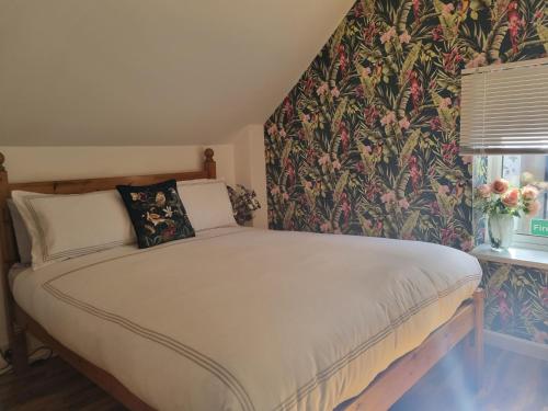 a bedroom with a bed with a floral wallpaper at Seagulls Nest Holiday Cottage in Blackpool