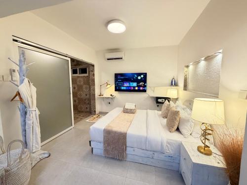 a bedroom with a large bed and a television at Studio Crème by The Prime Escape in Arusha