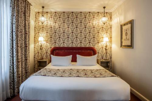 a bedroom with a large bed with two pillows at Best Western Plus Hotel Villa D'est in Strasbourg