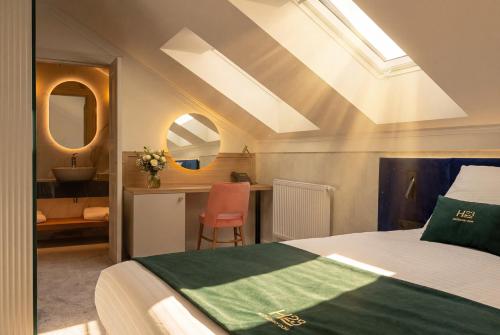 a bedroom with a bed and a bathroom with a sink at Boutique Hotel H23 in Pezinok