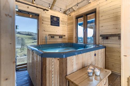 a jacuzzi tub in a wooden cabin at Villa Ligęzówka in Chyrowa