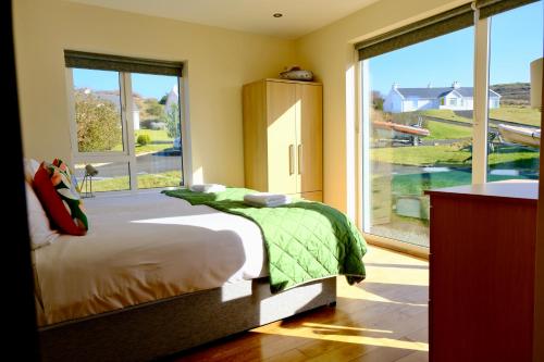 a bedroom with a bed and a large window at 4 Bedroom House By Travel Lets Holiday Homes Downings With Atlantic View in Downings