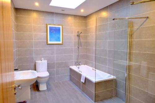 a bathroom with a shower and a toilet and a sink at 4 Bedroom House By Travel Lets Holiday Homes Downings With Atlantic View in Downings