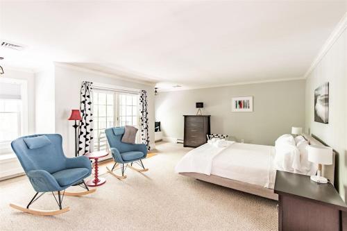 a bedroom with a bed and two blue chairs at Mystic Landing in Kennebunk