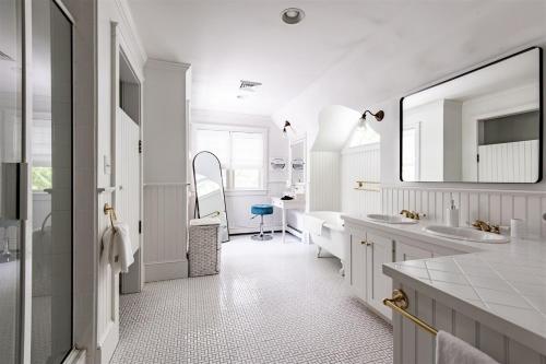 a white bathroom with two sinks and a mirror at Mystic Landing in Kennebunk