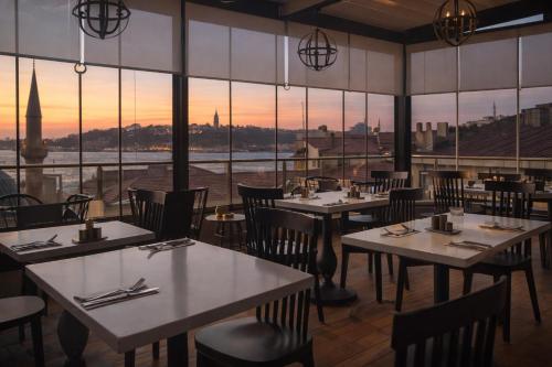 a restaurant with tables and chairs and a view of the city at Ada Karakoy Hotel - Special Category in Istanbul