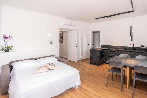a bedroom with a white bed and a dining table at DN ART BLEVIO - Romantic Lake Como Apartment with Indoor Jacuzzi - 5 guests in Blevio