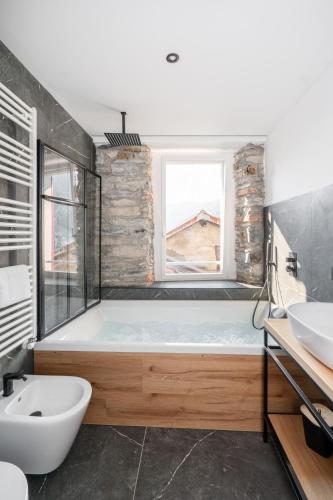 a bathroom with a bath tub and a sink at DN ART BLEVIO - Romantic Lake Como Apartment with Indoor Jacuzzi - 5 guests in Blevio