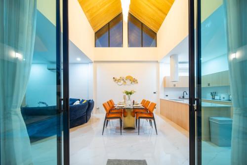 a dining room and kitchen with a wooden table and chairs at Yuan Villa VIP in Rawai Beach