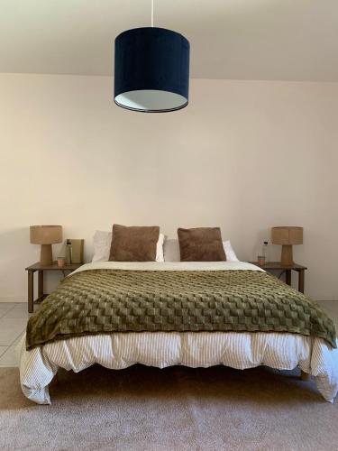 a bedroom with a large bed with a blue lamp at Les Toits d'Aniane in Aniane
