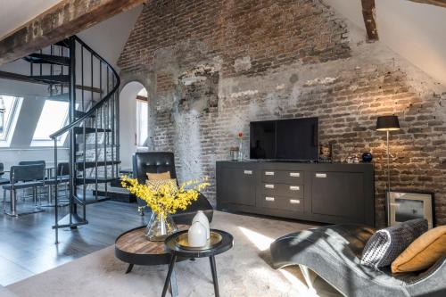 a living room with a brick wall at Huize de Lekpoort - The Cloister Wall - Historic Apartment in Vianen Center in Vianen