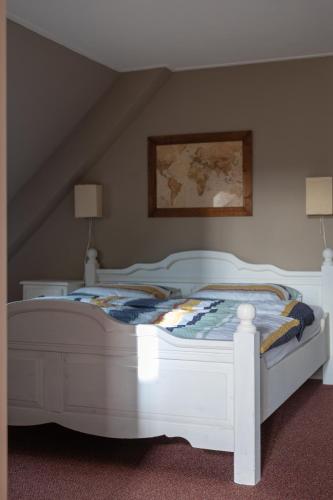 a bedroom with a white bed in a attic at Achterom in Biggekerke