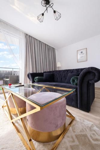 a living room with a glass table and a couch at Modern 2-Room Apartment with Large Balcony & Private Parking in Gdańsk