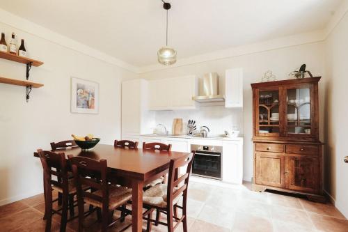 a kitchen with a wooden dining table and chairs at historical townhome in Poppi in Poppi