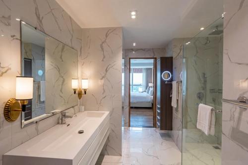 a bathroom with a large sink and a shower at Walk-Inn Centaurus Hotel Apartments Islamabad in Islamabad