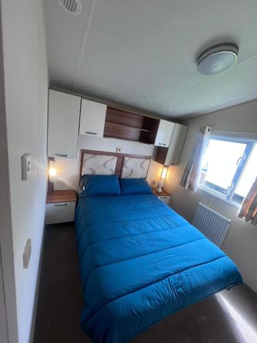 a large blue bed in a small room at ellies caravan hire 8 berth in Kinmel Bay