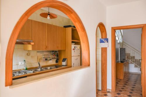 a kitchen with an arch over a sink and a refrigerator at Da Nonna Mena in Fossacesia