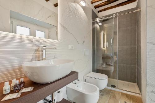 a white bathroom with a sink and a toilet at Il Fiore del Prione in La Spezia