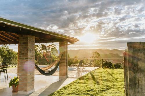 a hammock on a patio with a view of the mountains at Chalé 1 Refúgio do Sol Piscina com Vista para Montanas in Socorro