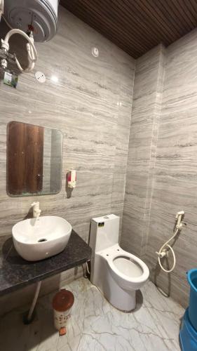 a bathroom with a white toilet and a sink at Hotel Tara Grand in Mathura