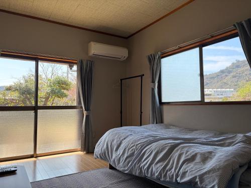 a bedroom with a bed and two large windows at Bunkyo in Naoshima