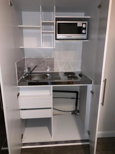 a small kitchen with a sink and a microwave at M Studio in Raynes Park