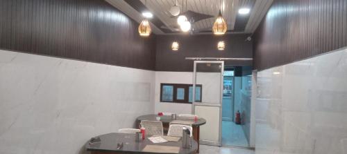 a room with a table and chairs in a building at Astha Restorent & Geust House in Aonla