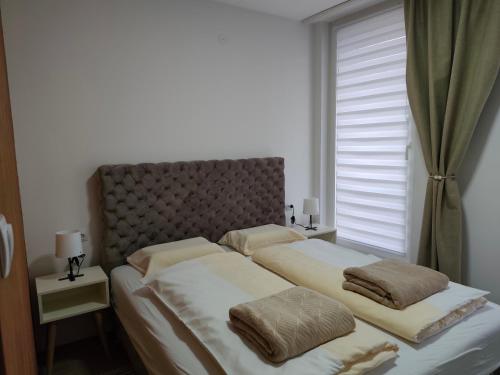 a bedroom with two beds and a window at Six Windows Apartmani in Bačka Topola