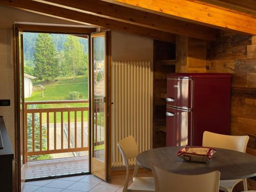 a kitchen with a table and a refrigerator at Bilocale baciato dal sole in Andalo