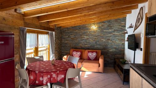 a kitchen and living room with a table and a couch at Bilocale baciato dal sole in Andalo