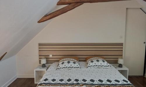 a bedroom with a bed with a wooden headboard at Bed and Breakfast au calme in Avoise