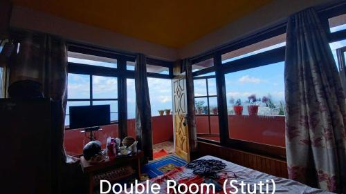 a bedroom with a bed and a window with a view at Homestay in Darjeeling By NE DEN in Jāmb