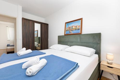 a bedroom with two beds with towels on them at Apartman Dokić 3 in Vrbnik