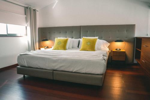 a bedroom with a large bed with two yellow pillows at Rauls Place in Madalena