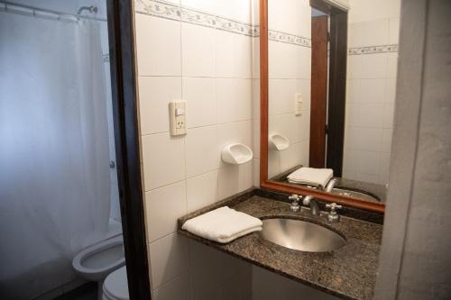 a bathroom with a sink and a mirror and a toilet at Green House in Villa General Belgrano