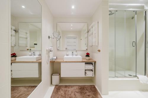 a bathroom with two sinks and a shower at Hotel w Dobieszkowie in Stryków