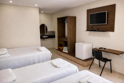 a hotel room with two beds and a television at Rio Preto Hotel in Formosa