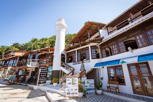 ein Leuchtturm in der Mitte einer Straße mit Gebäuden in der Unterkunft Pousada Farol do Morro in Morro de São Paulo