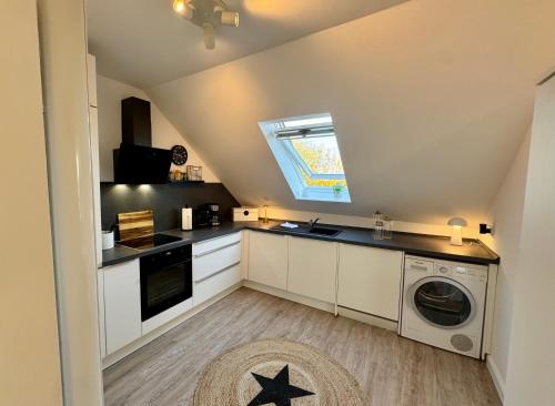 a small kitchen with a washer and dryer at Vollmöbliertes Apartment am Deich in Neuendeich