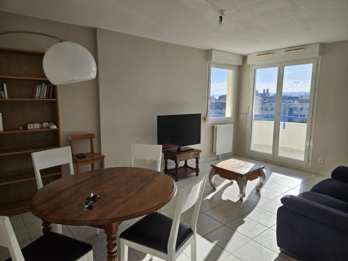 a living room with a table and a couch at La maison de Pommard in Dijon