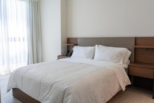 a bedroom with a large bed with white sheets and pillows at Condo Suite 2BR With View in Panama City