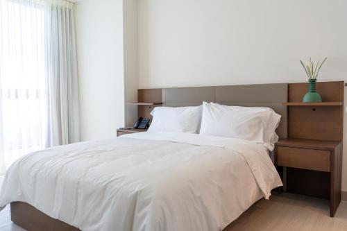 a bedroom with a large bed with a white comforter at Condo Suite 2BR With View in Panama City